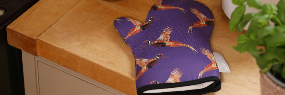 Pheasant oven mitt on a kitchen work top with basil