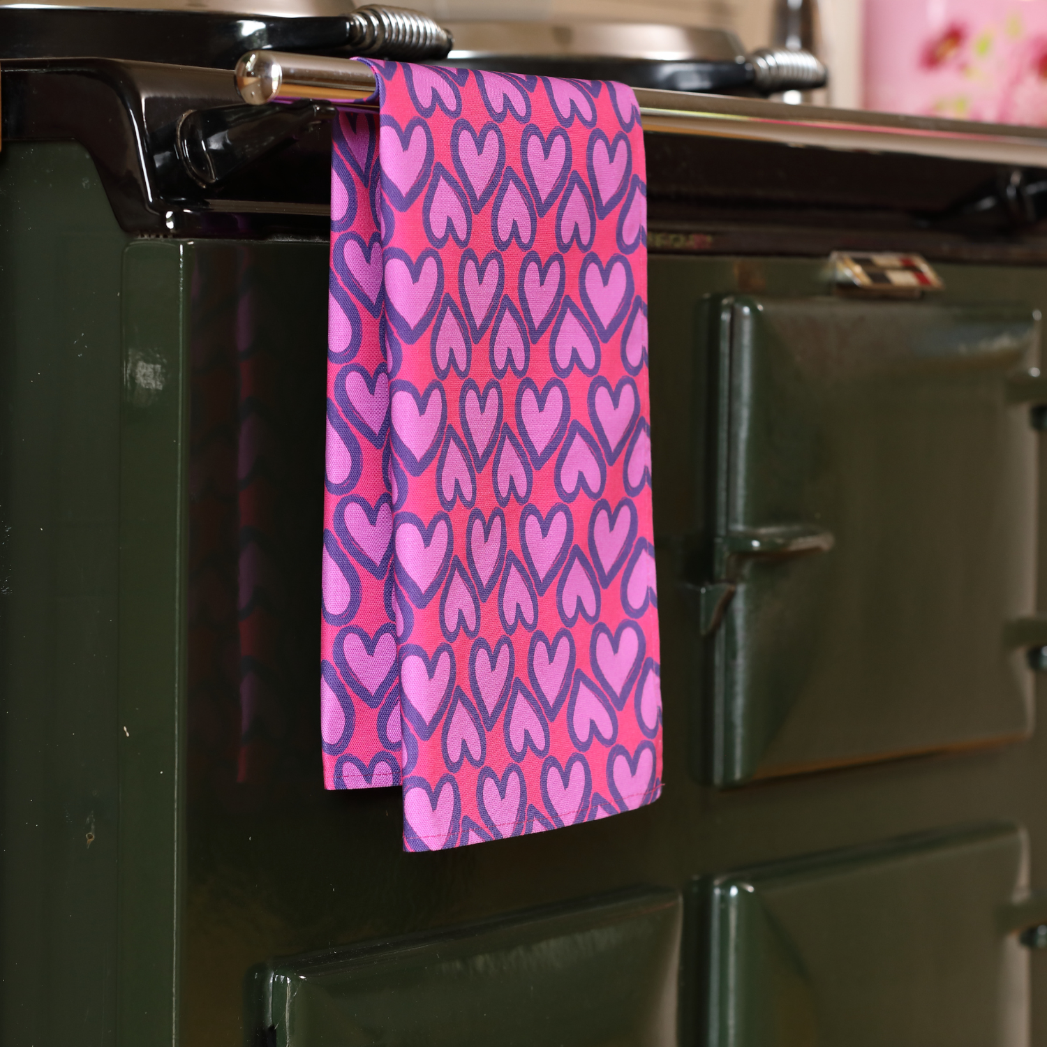 Hand-illustrated Heart Tea Towel in Pink by Tracey Cooper — 100% cotton, printed in the UK, featuring playful hearts on a soft pink background.