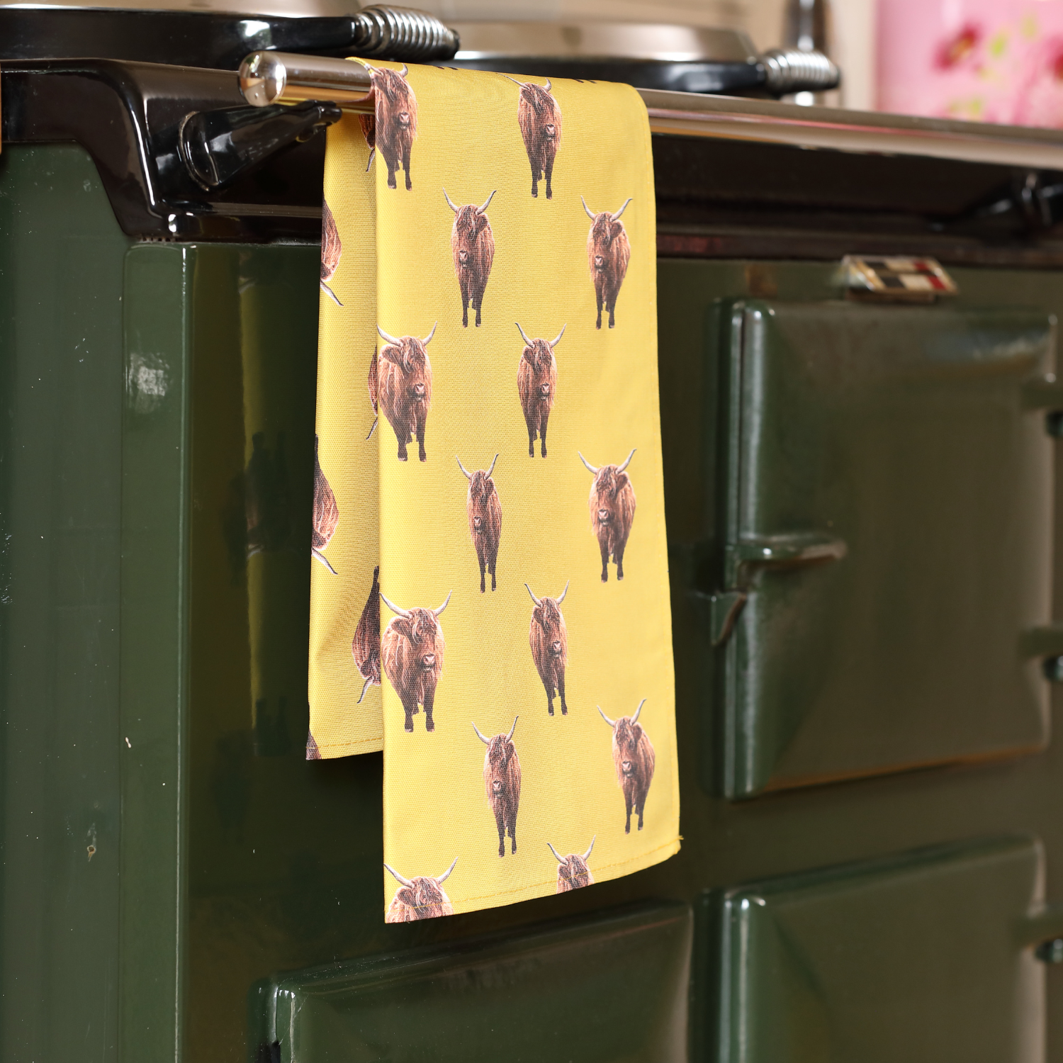 Hand-illustrated Highland Cow Tea Towel by Tracey Cooper — 100% cotton, printed in the UK, featuring a rustic yellow backdrop and countryside charm.