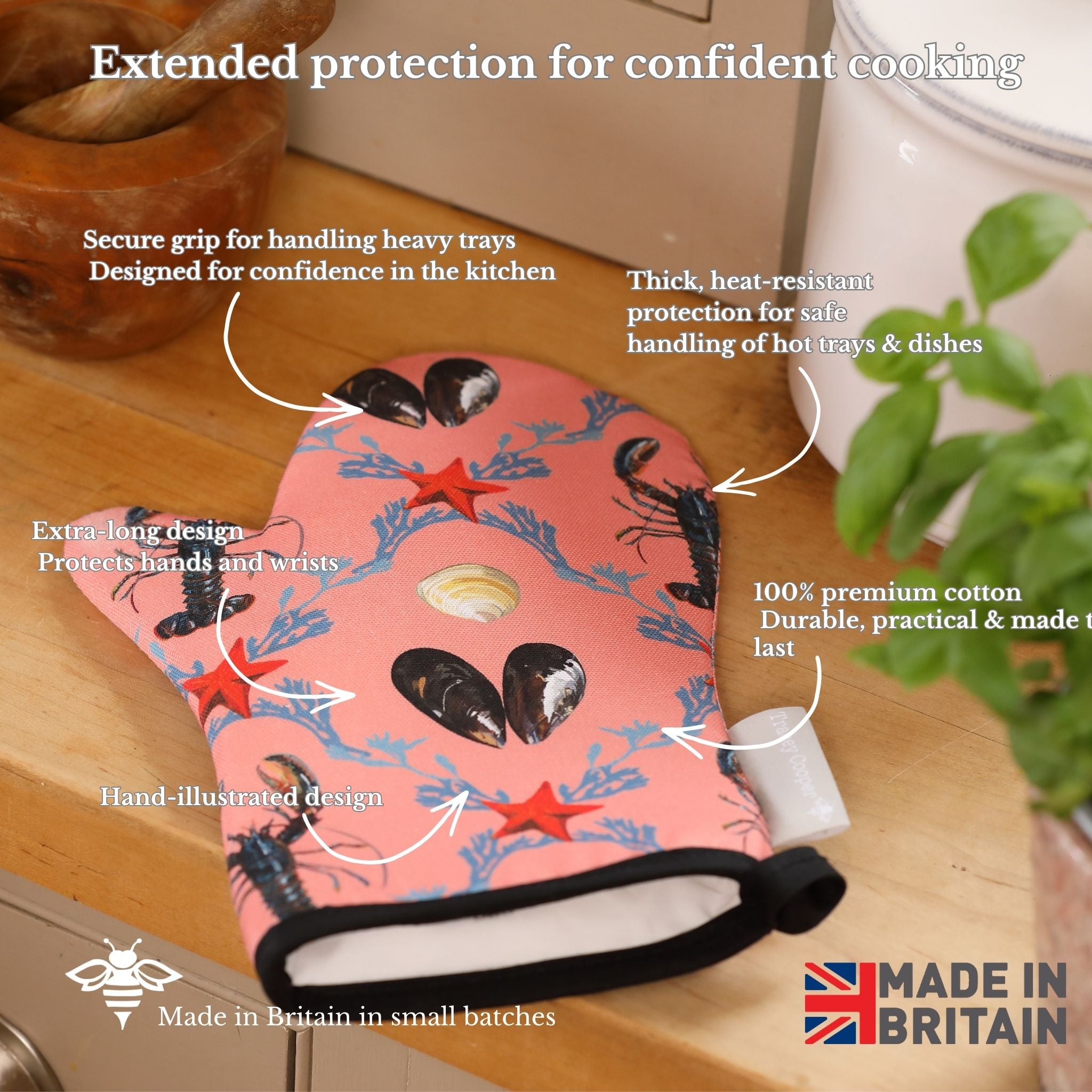 Oven mitt with sea-themed design on a kitchen counter, featuring text about its features and made in Britain label.
