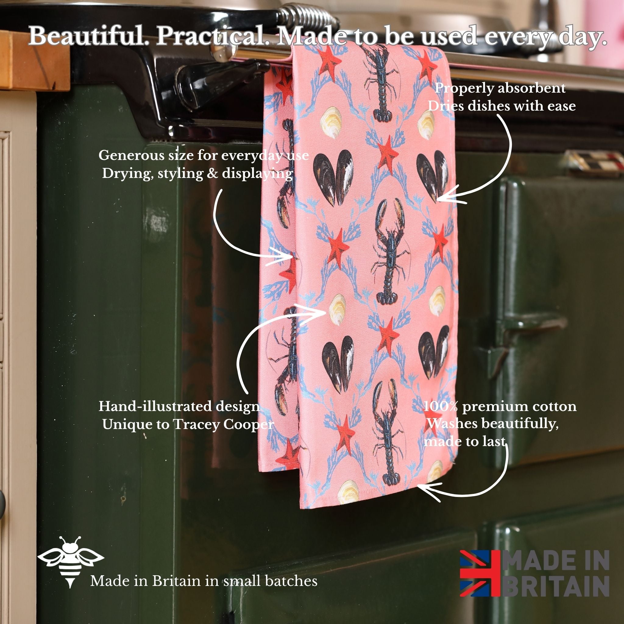 Pink towel with lobster pattern hanging on a kitchen rack, with text describing its features.