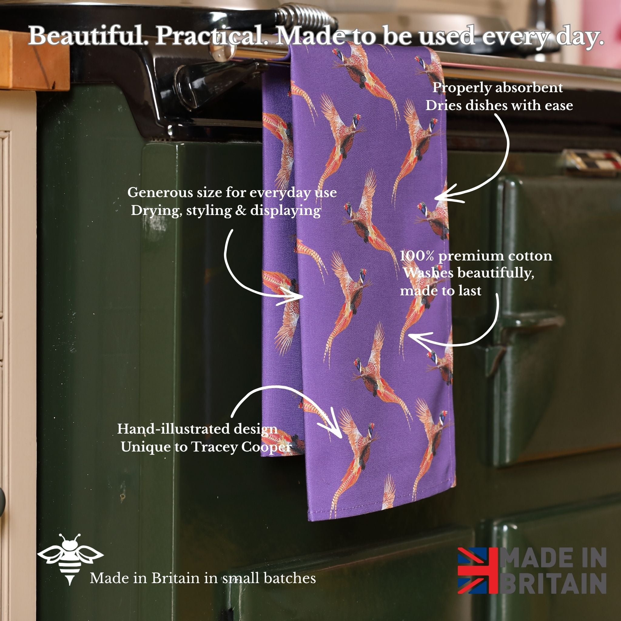 Purple towel with bird pattern hanging on a kitchen rack, with text describing its features.