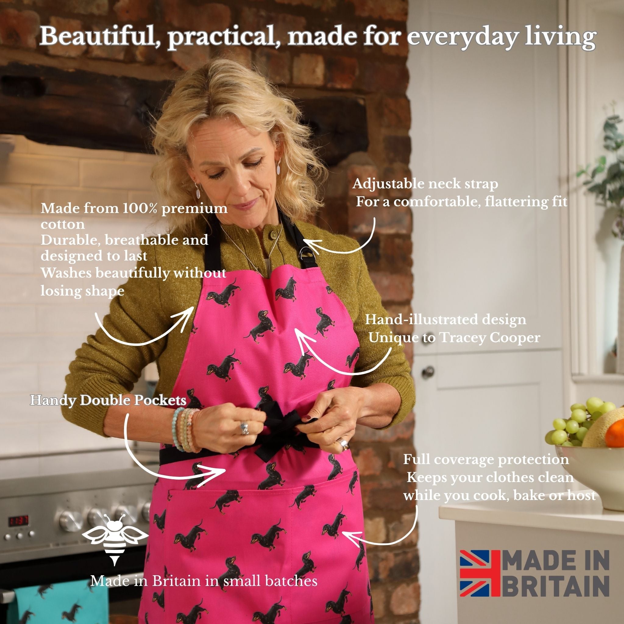 Hand-illustrated Sausage Dog Apron by Tracey Cooper — 100% cotton, printed in the UK, featuring a detailed Sausage Dog design on pink with pockets.