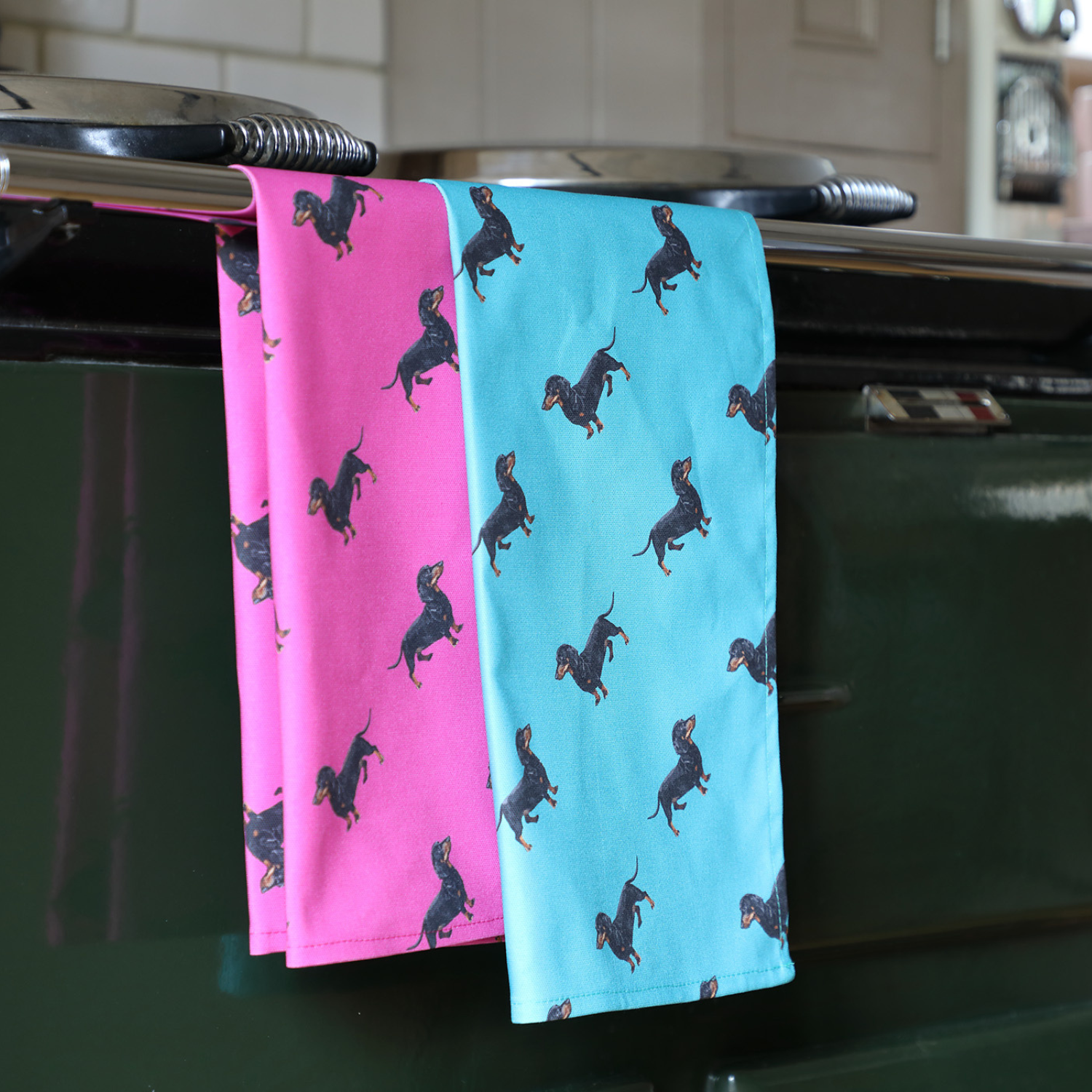 Hand-illustrated Sausage Dog Tea Towel by Tracey Cooper — 100% cotton, printed in the UK, available in pink, bright pink, or teal.