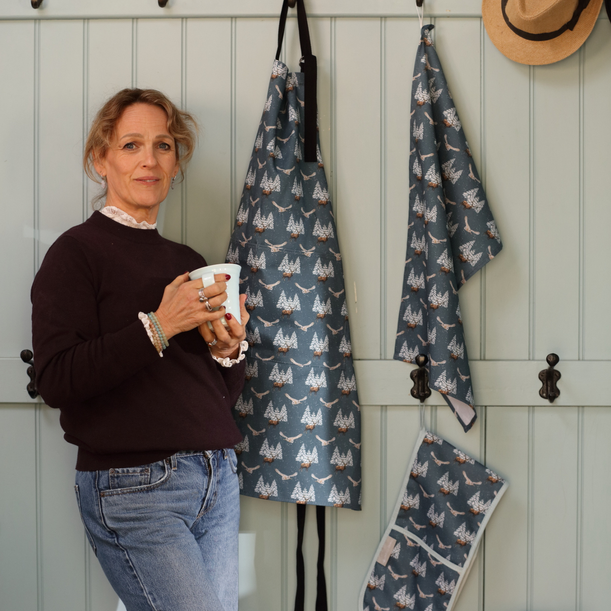 A photo of Tracey Cooper the artist with a range of her kitchen linens