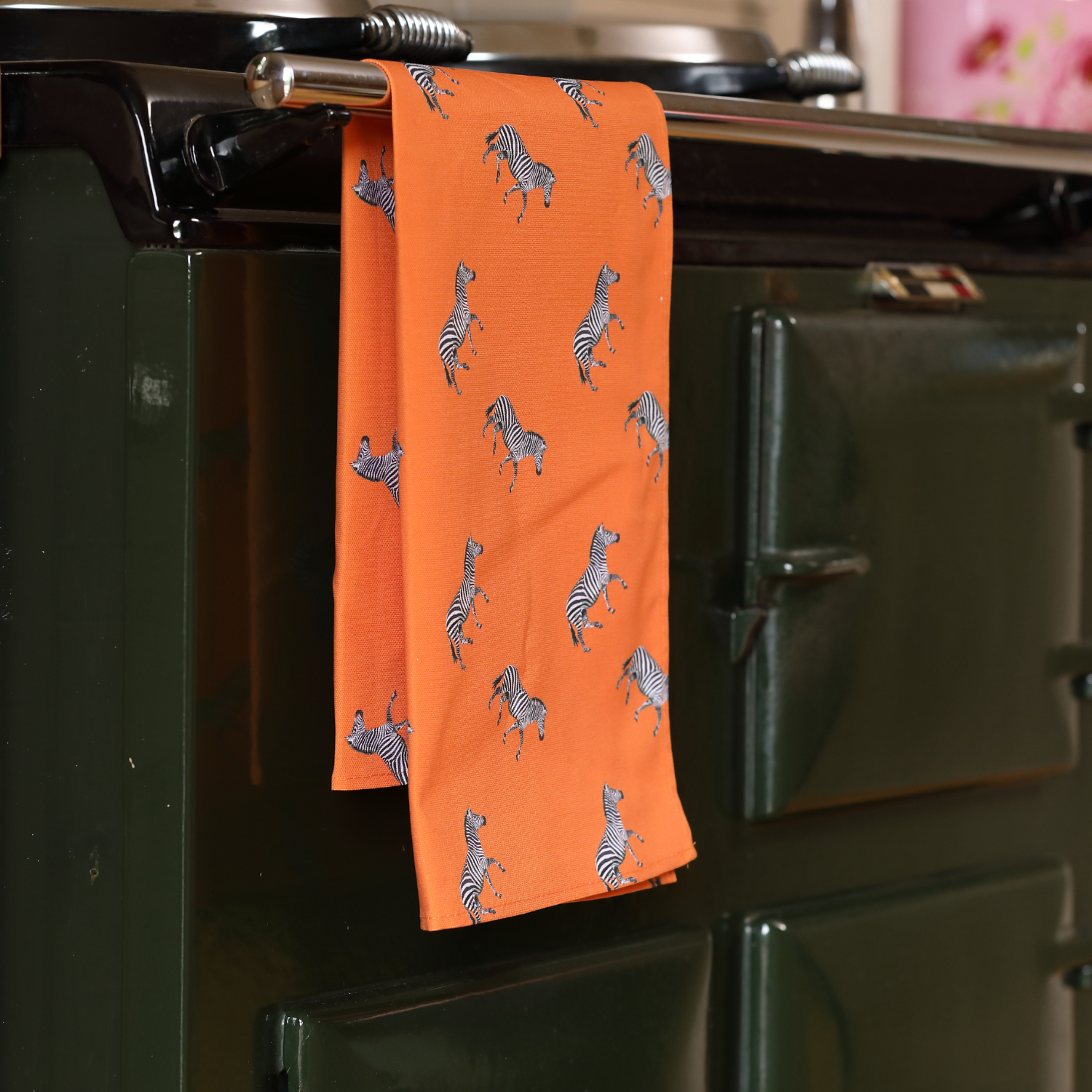 Hand-illustrated Zebra Tea Towel by Tracey Cooper — 100% cotton, printed in the UK, featuring bold zebras on a vibrant orange background.