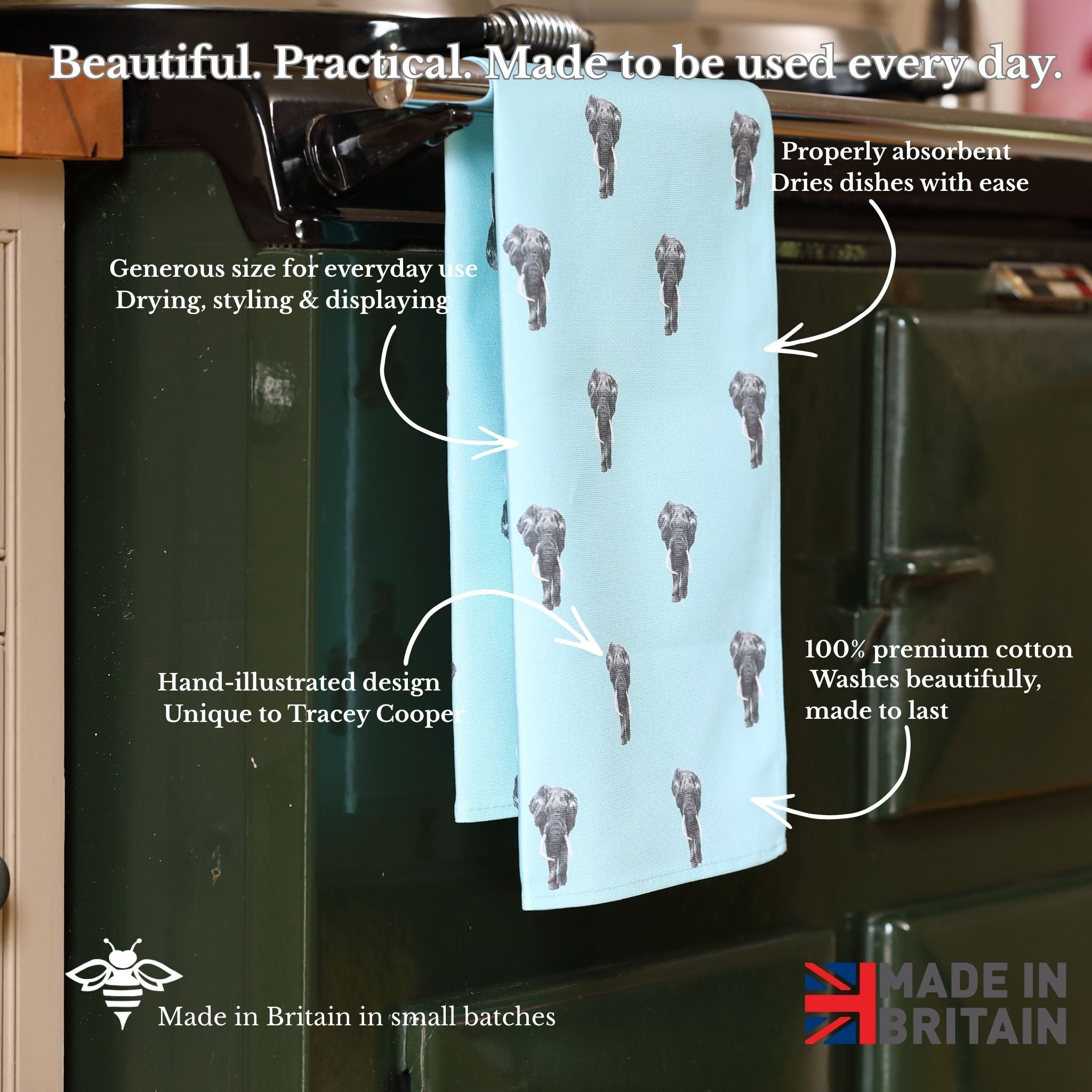 Tea towel with hand-illustrated design hanging on a kitchen rack, with text highlighting features.