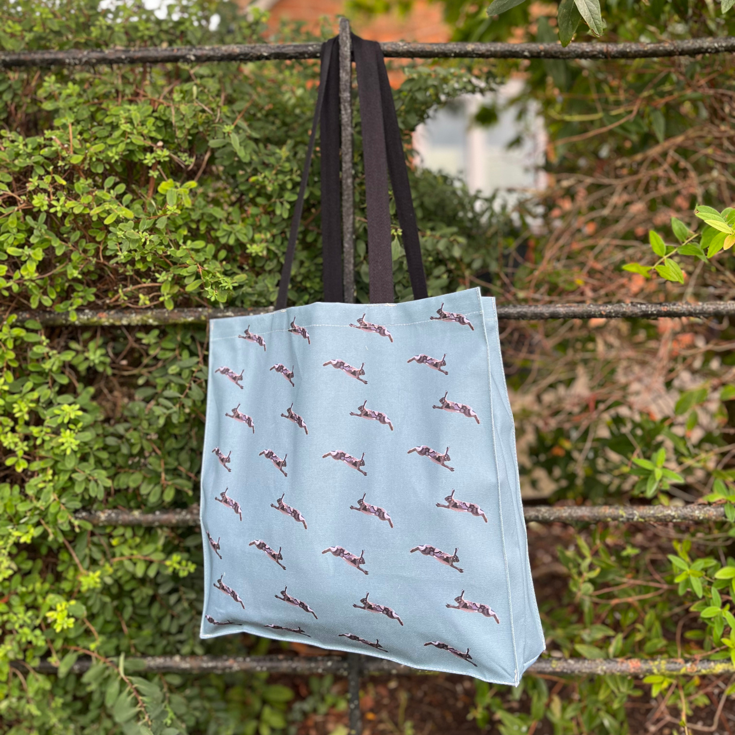 Sage green hare tote bag with repeat hare pattern on back