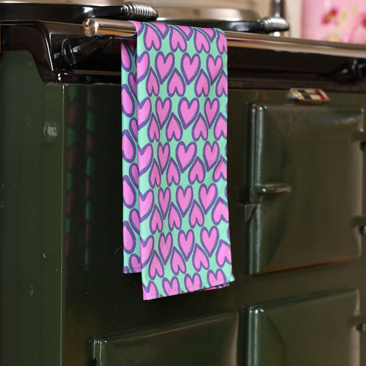 Hand-illustrated Heart Tea Towel in Green by Tracey Cooper — 100% cotton, printed in the UK, featuring a vibrant green background and playful heart motif.
