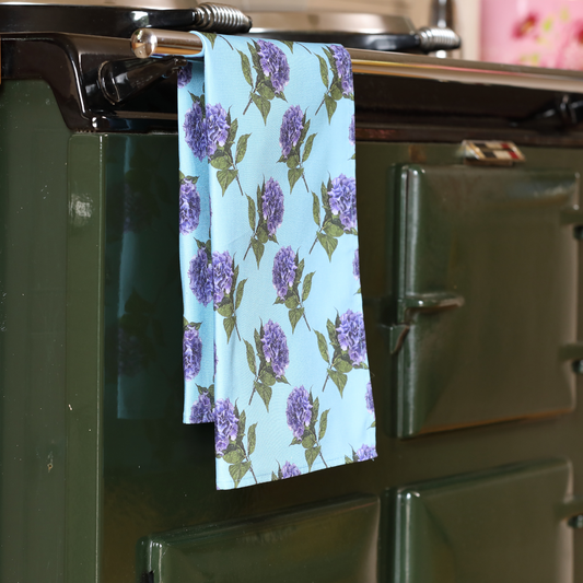 Hand-illustrated Hydrangea Tea Towel by Tracey Cooper — 100% cotton, printed in the UK, featuring a serene blue backdrop and floral elegance.