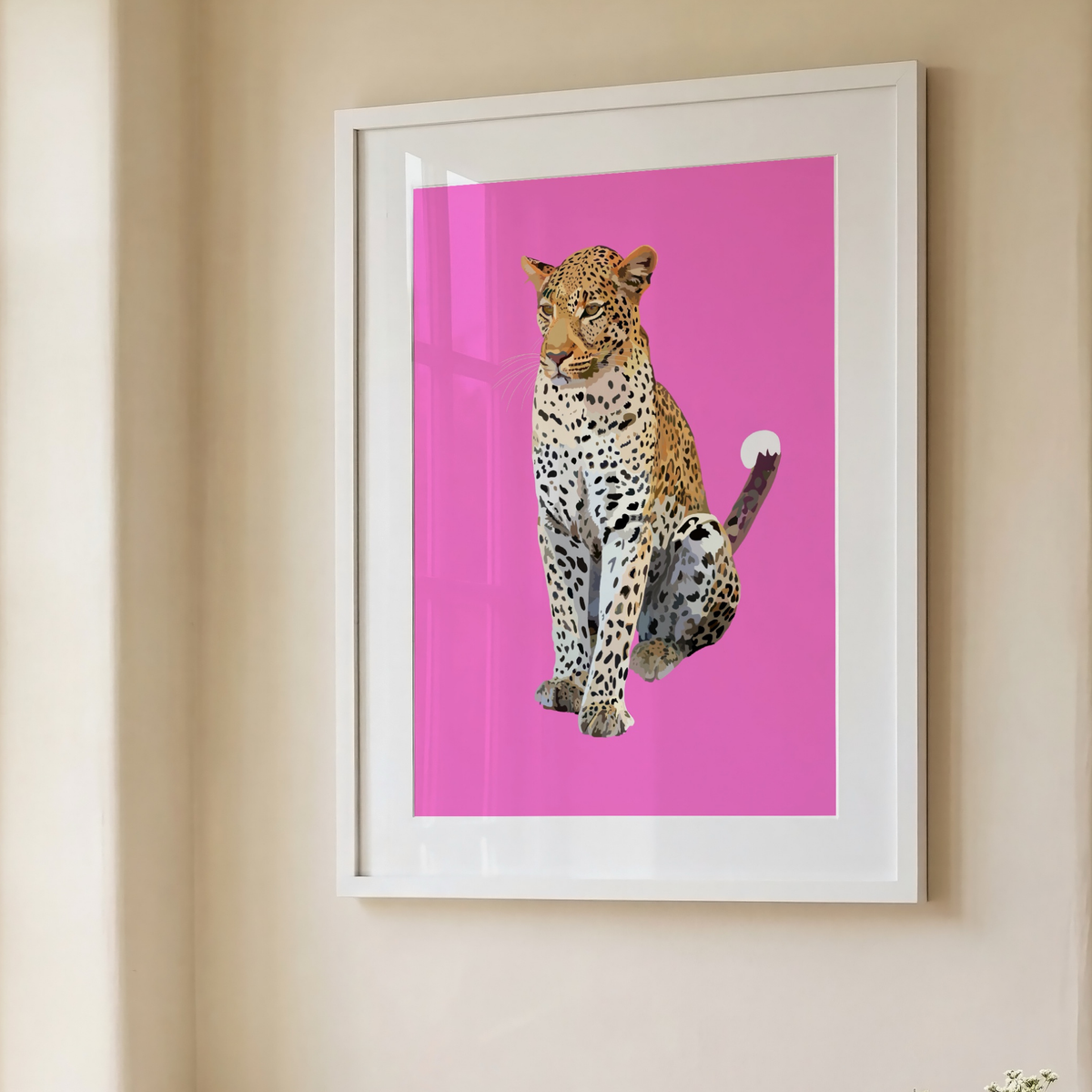 A framed art print featuring a realistic leopard cutout on a bright pink background, hung on a beige wall.