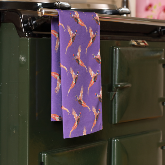 Hand-illustrated Pheasant Tea Towel by Tracey Cooper — 100% cotton, printed in the UK, featuring a rich purple backdrop and countryside charm.