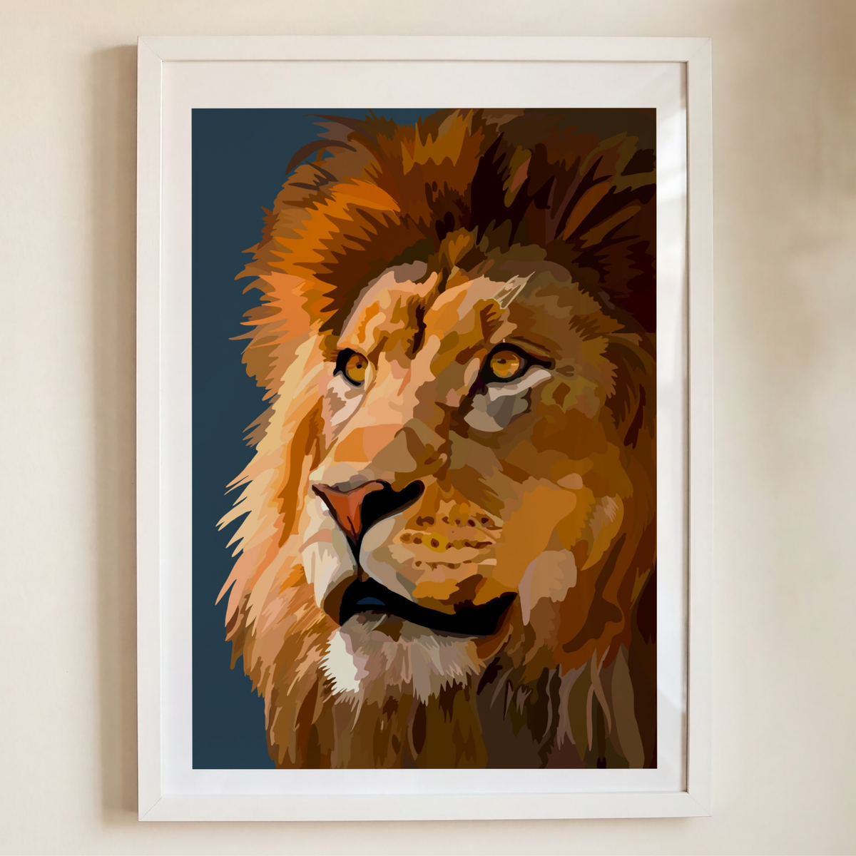 A framed art print of a stylized lion portrait, featuring warm golden-brown and orange tones against a dark blue background, housed in a white frame and mounted on a light beige wall.