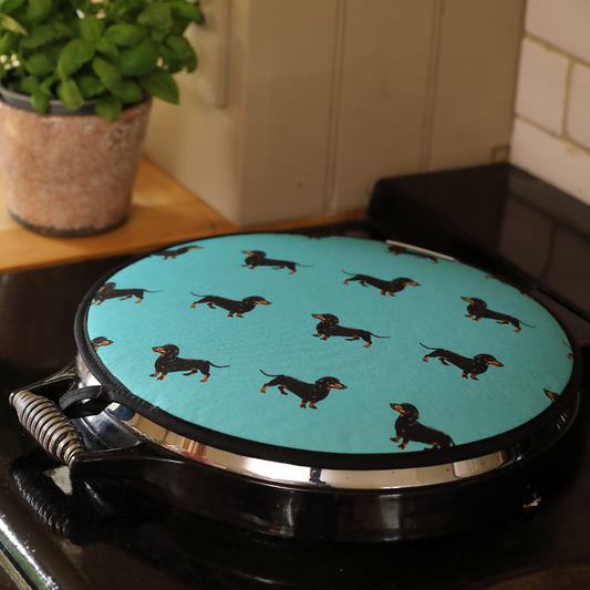 Hand-illustrated sausage dog hob cover in teal designed for Aga cookers